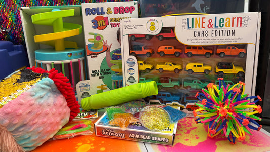 Assorted educational toys on a colorful surface with a multicolored textured wall in the background.